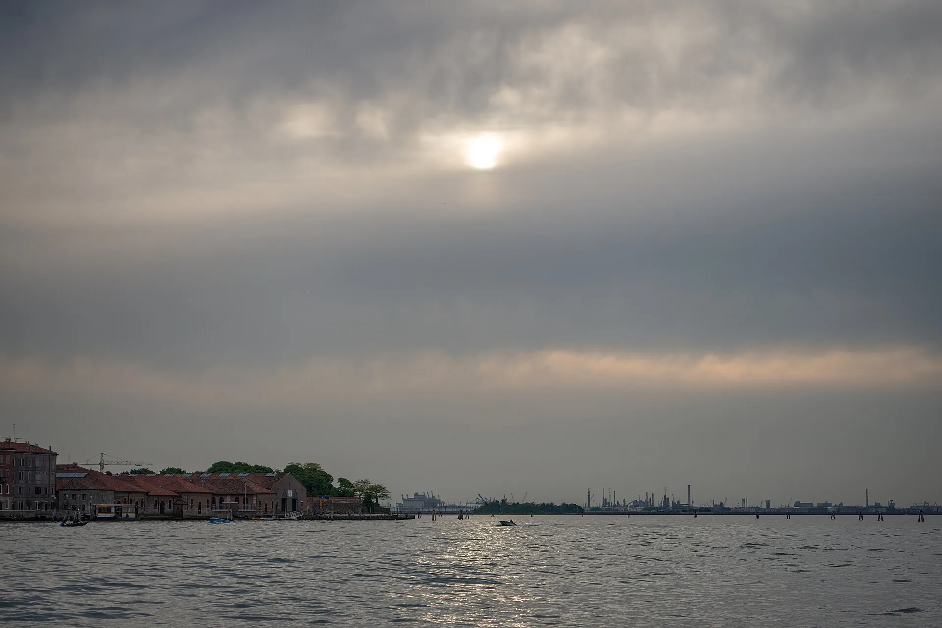 Tramonto sulla laguna di Venezia visto dall'acqua, con il cielo arancione riflesso sul mare